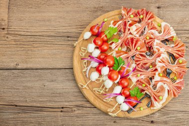 Şişe üzerinde piknik atıştırmalıkları. Jamon, mozzarella, kiraz domatesleri, bezelyeler, taze yeşiller. Modern duruş, ahşap arkaplan, üst manzara