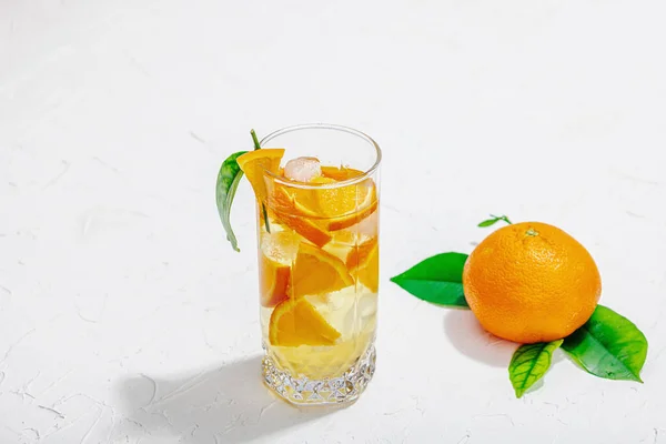 橙子鸡尾酒加冰块和成熟的水果重温季节性饮料 概念背景为绿色柑橘叶 现代风格 选择性焦点 黑暗阴影 复制空间 — 图库照片