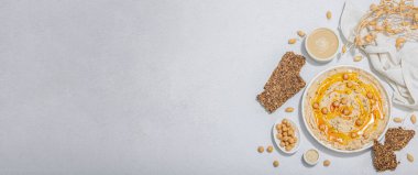 Zeytinyağlı humus ve çıtır ekmek. Sağlıklı yaşam tarzı için vazgeçilmez bir malzeme. Rahatlatıcı yemekler, vejetaryen atıştırmalıkları. Sert ışık, koyu gölge, taş beton zemin, düz döşeme, afiş biçimi