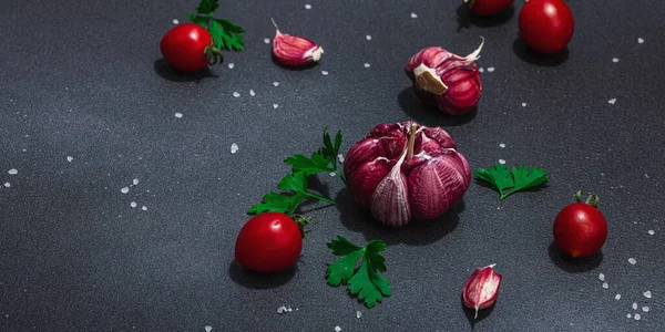 新鮮な野菜やハーブと料理の背景 トマトチェリー ニンニク パセリ フラットレイアウト ハードライト 暗い影 黒の石の具体的な背景 — ストック写真
