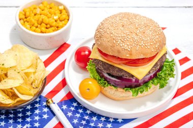 Ev yapımı hamburgerler. Amerikan klasiği, geleneksel piknik, parti ya da Bağımsızlık Günü yemeği. Sert ışık, karanlık gölge, düz uzanma, beyaz ahşap zemin, kapat