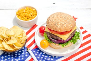 Ev yapımı hamburgerler. Amerikan klasiği, geleneksel piknik, parti ya da Bağımsızlık Günü yemeği. Sert ışık, karanlık gölge, düz uzanma, beyaz ahşap zemin, kapat