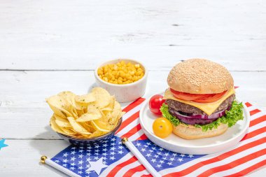 Ev yapımı hamburgerler. Amerikan klasiği, geleneksel piknik, parti ya da Bağımsızlık Günü yemeği. Sert ışık, karanlık gölge, düz zemin, beyaz ahşap zemin, kopyalama alanı