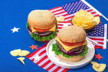 Ev yapımı hamburgerler. Amerikan klasiği, geleneksel piknik, parti ya da Bağımsızlık Günü yemeği. Sert ışık, koyu gölge, düz uzanma, mavi arkaplan, kapat