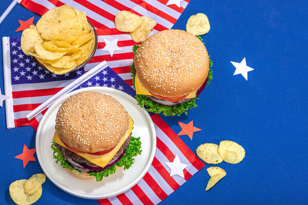 Homemade burgers. An American classic, traditional food for picnic, party or celebration Independence Day. Hard light, dark shadow, flat lay, blue background, top view