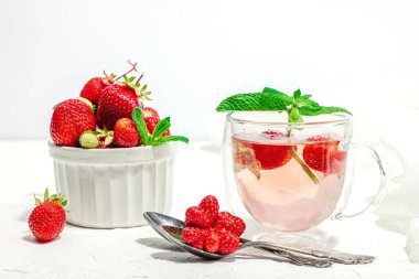 Çilek çayı konsepti. Günaydın konsepti. Çaydanlık, olgun meyve, sağlıklı içecek. Sert ışık, koyu gölge, beyaz arkaplan, boşluğu kopyala