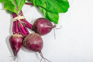 Taze pancar kökü, yemek pişirmek için sağlıklı malzeme. Modaya uygun sert ışık, koyu gölge, beyaz alçı arka plan, düz alan, üst manzara