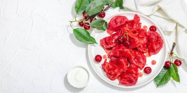 Hamur tatlısı, taze kiraz. Olgun meyveler, tatlı sos, taze ekşi krema. Geleneksel Ukrayna yemeği, moda vejetaryen yemekleri. Beyaz ahşap arka plan, sert ışık, karanlık gölge, afiş forta