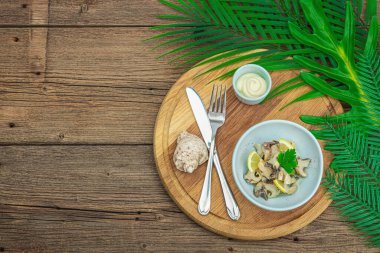 Yağlı, baharatlı ve yeşillikli Rapana istiridye eti. Sağlıklı deniz ürünleri omega açısından zengindir. Deniz dekoru, ahşap zemin, düz yatış, üst manzara.