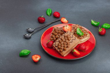 Taze çilekli lezzetli çikolatalı kekler. Tatlı tatlı, günaydın konsepti. Ev yapımı pişirme, krema, sos. Koyu taş arkaplan, kopyalama alanı