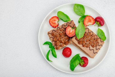 Taze çilekli lezzetli çikolatalı kekler. Tatlı tatlı, günaydın konsepti. Ev yapımı pişirme, krema, sos. Hafif taş arkaplan, üst görünüm