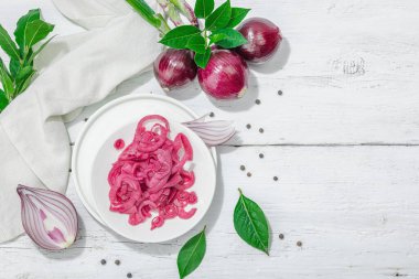 Beyaz masada lezzetli kırmızı soğan turşusu. Hazır yemek, modaya uygun sert ışık, karanlık gölge. Beyaz ahşap arkaplan, üst görünüm