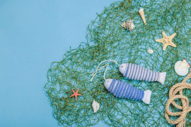 El yapımı denizci konsepti. Tığ işi sardalya balıkları, deniz usulü. Balık ağı, geleneksel deniz dekoru. Sert ışık, koyu gölge, modaya uygun mavi arkaplan, üst görünüm