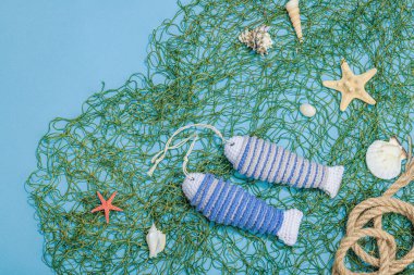 El yapımı denizci konsepti. Tığ işi sardalya balıkları, deniz usulü. Balık ağı, geleneksel deniz dekoru. Sert ışık, koyu gölge, modaya uygun mavi arkaplan, üst görünüm