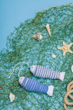 El yapımı denizci konsepti. Tığ işi sardalya balıkları, deniz usulü. Balık ağı, geleneksel deniz dekoru. Sert ışık, koyu gölge, modaya uygun mavi arkaplan, üst görünüm