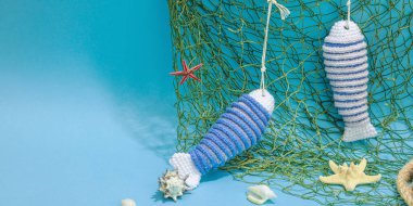 El yapımı denizci konsepti. Tığ işi sardalya balıkları, deniz usulü. Balık ağı, geleneksel deniz dekoru. Sert ışık, koyu gölge, modaya uygun mavi arkaplan, pankart biçimi