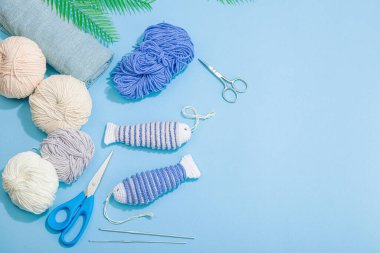 El yapımı denizci konsepti. Tığ işi sardalya balıkları, denizcilik tarzı, geleneksel deniz dekoru. Sert ışık, koyu gölge, modaya uygun mavi arkaplan, üst görünüm