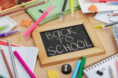 Okul konseptine geri dönelim. Sonbahar yaprakları, yazı tahtası. Ofis malzemeleri ile iş geçmişi, ahşap masa, düz yatak, yakın çekim