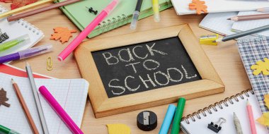 Okul konseptine geri dönelim. Sonbahar yaprakları, yazı tahtası. Ofis malzemeleri ile iş geçmişi, ahşap masa, düz döşeme, afiş biçimi