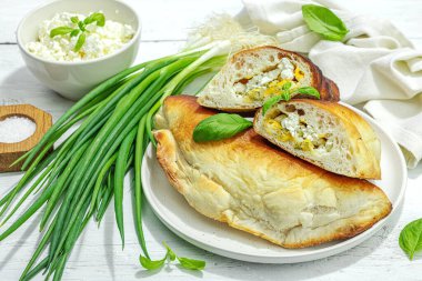 Süzme peynirli ve yeşillikli ev yapımı börek turtaları. Yüksek proteinli yiyecekler, glütensiz fırın. Modaya uygun sert ışık, karanlık gölge, beyaz ahşap arka plan, kapat