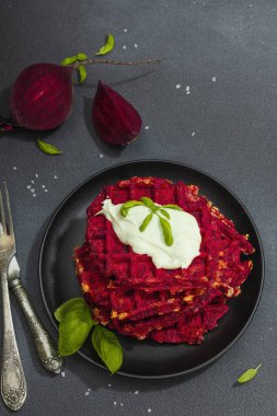 Ev yapımı Belçika usulü soslu pancar. Sebzeli glütensiz vegan yemeği. Modaya uygun sert ışık, koyu gölge, siyah taş beton zemin, üst görünüm