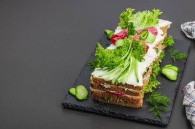 İsveç sandviçi Smorgastarta. Geleneksel soğuk aperatif servisi, yemeye hazır. Modern duruş, şenlikli yemek, siyah taş beton zemin, kopyalama alanı