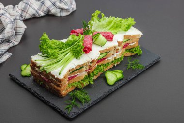 İsveç sandviçi Smorgastarta. Geleneksel soğuk aperatif servisi, yemeye hazır. Modern duruş, şenlikli yemek, siyah taş beton zemin, kopyalama alanı