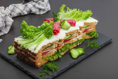 İsveç sandviçi Smorgastarta. Geleneksel soğuk aperatif servisi, yemeye hazır. Modern duruş, şenlikli yemek, siyah taş beton zemin, kopyalama alanı