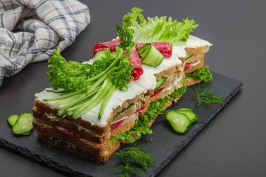 İsveç sandviçi Smorgastarta. Geleneksel soğuk aperatif servisi, yemeye hazır. Modern duruş, şenlikli yemek, siyah taş beton zemin, kopyalama alanı