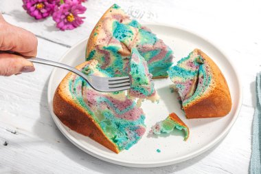 Tek boynuzlu at renginde elmalı turta yemeye hazır. Kadın eli çatal bıçak takımı, ev yapımı pişirme, nostaljik yemekler. Sert ışık, karanlık gölge, beyaz ahşap zemin, kopyalama alanı