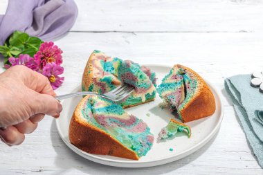 Tek boynuzlu at renginde elmalı turta yemeye hazır. Kadın eli çatal bıçak takımı, ev yapımı pişirme, nostaljik yemekler. Sert ışık, karanlık gölge, beyaz ahşap zemin, kopyalama alanı