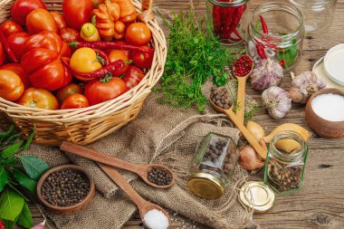 Korunmuş mevsim sebze konsepti. Domates, biber, yeşillik, soğan ve sarımsak hasadı. Baharatlı konserve yiyecekler, pişirme süreci için gerekli malzemeler. Sağlıklı tarifler, ev yemekleri, yakın çekim.