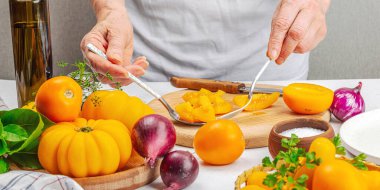 Bir kadın domates salatası hazırlıyor. Olgun sebzeler, bitkiler, aromatik baharatlar, zeytinyağı. Ev yemeği, taze malzemeler, afiş biçimi