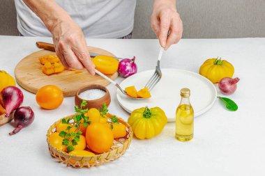 Bir kadın domates salatası hazırlıyor. Olgun sebzeler, bitkiler, aromatik baharatlar, zeytinyağı. Ev yemeği, taze malzemeler.