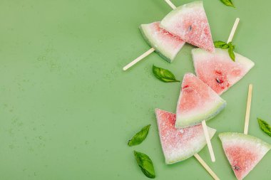Popüler Savannah yeşil arka planında donmuş karpuz dondurması. Serinletici yaz tatlıları, düz yatış, üst manzara