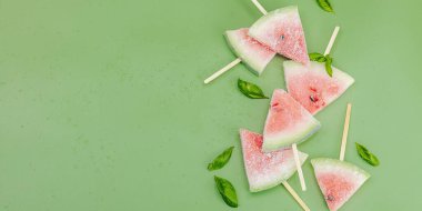 Popüler Savannah yeşil arka planında donmuş karpuz dondurması. Serinletici yaz tatlıları, düz yatış, afiş biçimi