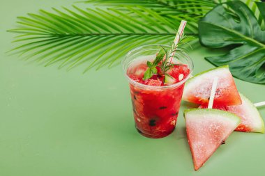 Karpuz kokteylini tazeliyorum. Geleneksel yaz içkisi. Moda Savannah yeşil arkaplan, palmiye yaprakları, kopyalama alanı