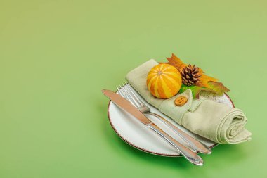 Sonbahar sofrası. Şükran Günü çatal bıçak takımı, geleneksel sonbahar dekorasyonu, düz yatış. Şenlik havası, balkabağı, yapraklar, Savannah Green arka planı, kopyalama alanı
