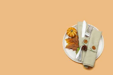Sonbahar sofrası. Şükran Günü çatal bıçak takımı, geleneksel sonbahar dekorasyonu, düz yatış. Neşeli bir ortam, balkabağı, yapraklar, sıcak turuncu arka plan, üst manzara.