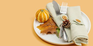 Sonbahar sofrası. Şükran Günü çatal bıçak takımı, geleneksel sonbahar dekorasyonu, düz yatış. Şenlik havası, balkabağı, yapraklar, ılık turuncu arka plan, afiş biçimi