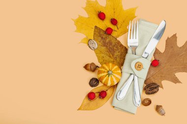 Sonbahar sofrası. Şükran Günü çatal bıçak takımı, geleneksel sonbahar dekorasyonu, düz yatış. Neşeli bir ortam, balkabağı, yapraklar, sıcak turuncu arka plan, üst manzara.