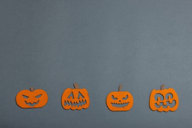 Komik cadılar bayramı geçmişi. Farklı yüzleri olan geleneksel renkli balkabakları. Şenlikli düz yatak, klasik sonbahar tarzı, üst görünüm