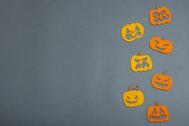 Komik cadılar bayramı geçmişi. Farklı yüzleri olan geleneksel renkli balkabakları. Şenlikli düz yatak, klasik sonbahar tarzı, üst görünüm