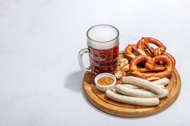 Geleneksel Ekim Festivali seti. Simitler, bira, hardallı sosis. Alman festivali yemek konsepti. Modaya uygun sert ışık, karanlık gölge, aydınlık taş zemin, kopyalama alanı