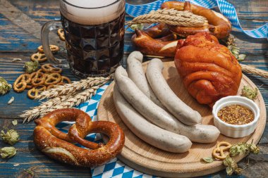 Geleneksel Ekim Festivali seti. Simitler, bira, sosis ve hardallı Eisbein. Alman festivali yemek konsepti. Modaya uygun sert ışık, karanlık gölge, ahşap arka plan, kapat