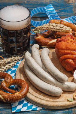 Geleneksel Ekim Festivali seti. Simitler, bira, sosis ve hardallı Eisbein. Alman festivali yemek konsepti. Modaya uygun sert ışık, karanlık gölge, ahşap arka plan, kapat
