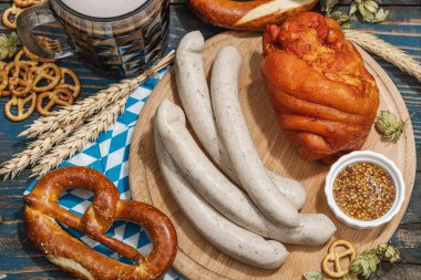 Geleneksel Ekim Festivali seti. Simitler, bira, sosis ve hardallı Eisbein. Alman festivali yemek konsepti. Modaya uygun sert ışık, koyu gölge, ahşap zemin, üst manzara
