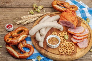 Geleneksel Ekim Festivali seti. Simitler, bira, sosis ve hardallı Eisbein. Alman festivali yemek konsepti. Moda ahşap arka plan, kapat