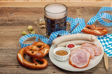 Traditional Oktoberfest set. Pretzels, beer, weisswurst and eisbein with mustard. German festival food concept. Trendy wooden background, copy space clipart