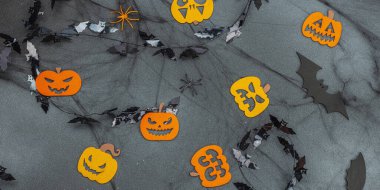 Komik cadılar bayramı geçmişi. Korkunç örümcek ağı, geleneksel sonbahar balkabakları, yarasalar ve örümcekler. Festive flat lay, klasik sonbahar stili, afiş biçimi